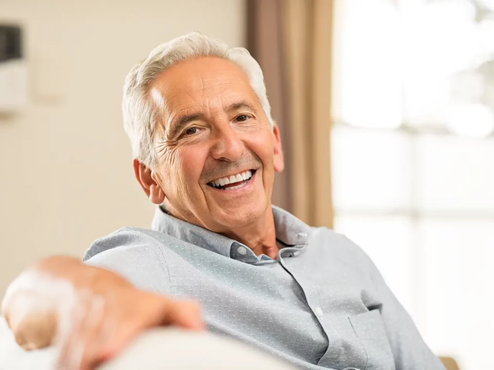 Denture specialist showing a set of dentures to a patient in Houston TX