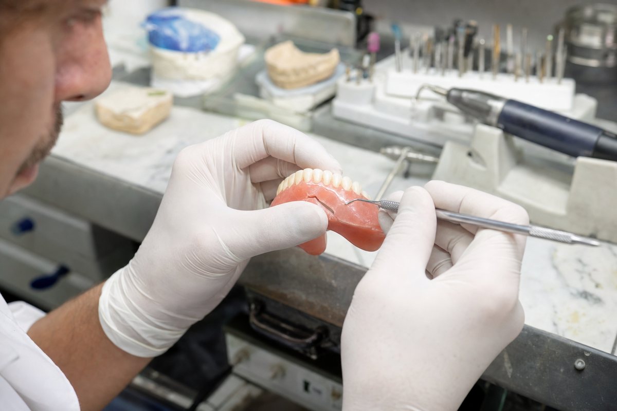 Dental Technician Repairing A Cracked Denture In The Lab